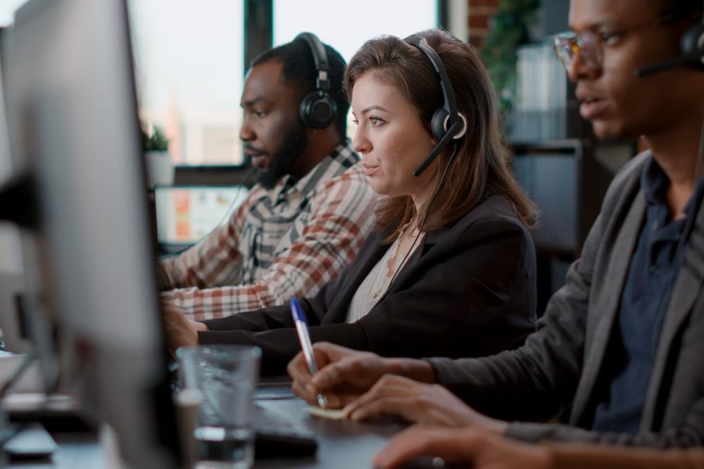 young-woman-using-audio-headset-computer-call-center-job-offering-helpline-assistance-people-female-consultant-talking-clients-customer-care-service-helping-with-telemarketing (1)